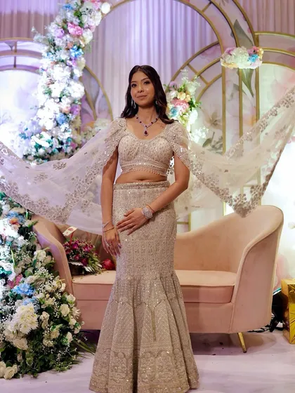 A full-length view of the bride in her stunning fish-cut lehenga. The makeup is elegant and understated, letting the dress and the decor shine.