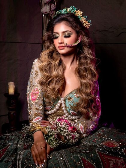 A serene moment captured, with eyes closed to showcase the beautiful green and gold eyeshadow blend. This look is perfect for a nature-inspired bride.