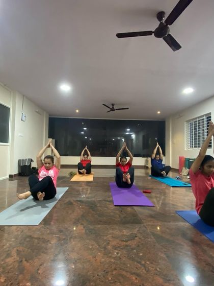 A class working on a variation of Navasana (Boat Pose). This core-strengthening pose is challenging but incredibly rewarding, and we build up to it step by step.