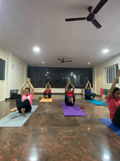 A class working on a variation of Navasana (Boat Pose). This core-strengthening pose is challenging but incredibly rewarding, and we build up to it step by step.