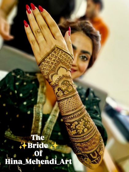 A lovely portrait of the bride, with her hand held up to showcase the detailed traditional mehendi on her arm.