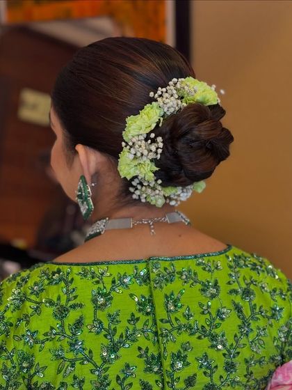 A beautiful example of how a floral bun can complement a colorful outfit.