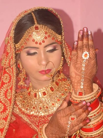 This bride is showing off her beautiful henna-adorned hands. The makeup features a soft pink lip and shimmery eyes.