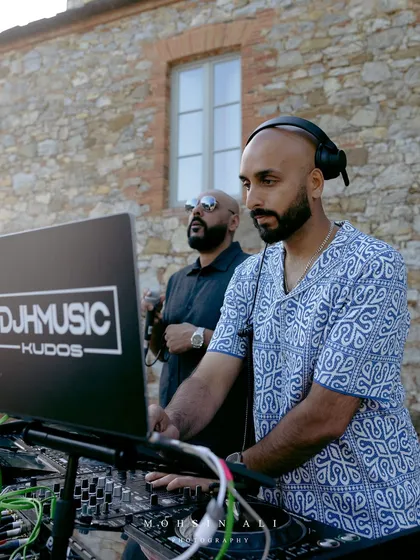 On the decks in Tuscany with my Kudos DJ partner. We're getting set up for an outdoor party, ready to blend our sound with the beautiful Italian landscape.
