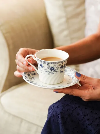 A lifestyle shot of a woman holding a teacup, capturing a quiet moment of relaxation. This is perfect for a brand selling ceramics or tea.