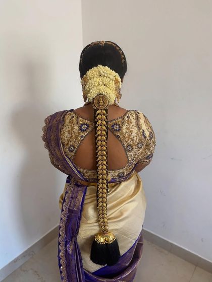 A full length view of a classic bridal braid with gold 'Jadai' and a jasmine 'Gajra'. This hairstyle is a perfect match for a traditional Kanjeevaram saree.