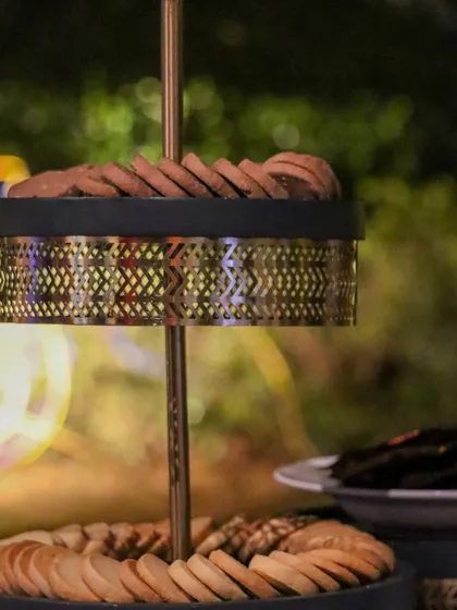 A stylish two-tiered stand with intricate metalwork, presenting a selection of our freshly baked cookies.
