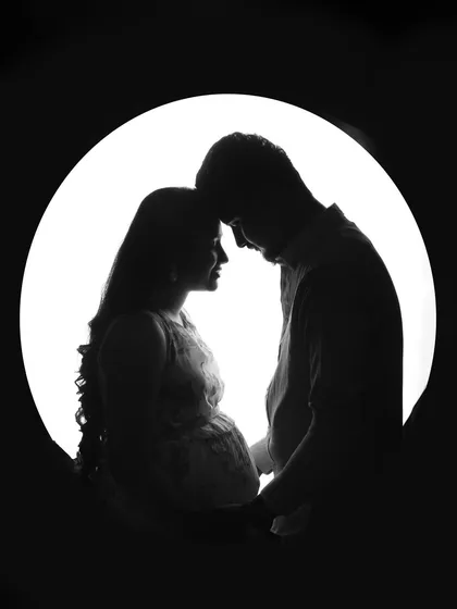 Sometimes, a silhouette tells the most powerful story. This artistic black and white maternity portrait captures the beautiful shape of motherhood and the quiet connection between a couple, waiting for their baby.