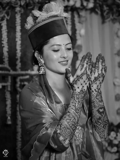 A classic black and white portrait of the bride, her smile and intricate henna design taking center stage.