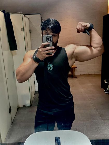 Showing off arm size and definition with wrist wraps on after a tough workout.