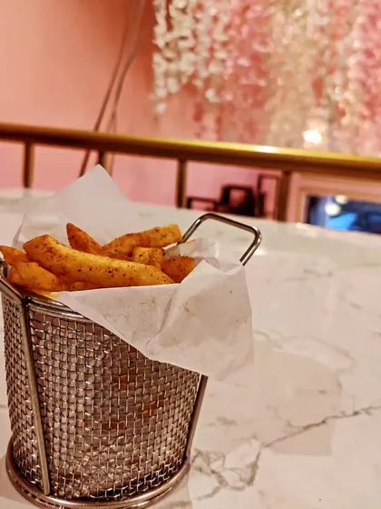 A basket of our crispy peri peri fries, perfectly seasoned for a spicy kick. This is a popular snack to enjoy any time of day at the cafe.