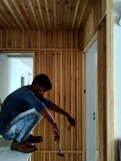 A behind-the-scenes moment of a craftsman at work on the pine wood paneling for the Gurgaon residence, highlighting the hands-on process of our designs.