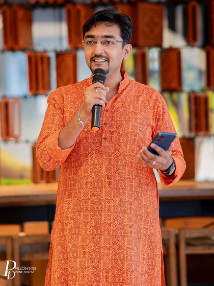 A smiling performer in a vibrant kurta shares his piece. Our events attract a diverse group of individuals, all connected by their love for words and storytelling.