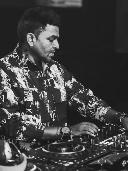 A black and white photo from behind the decks, capturing the focus and precision that goes into every mix.
