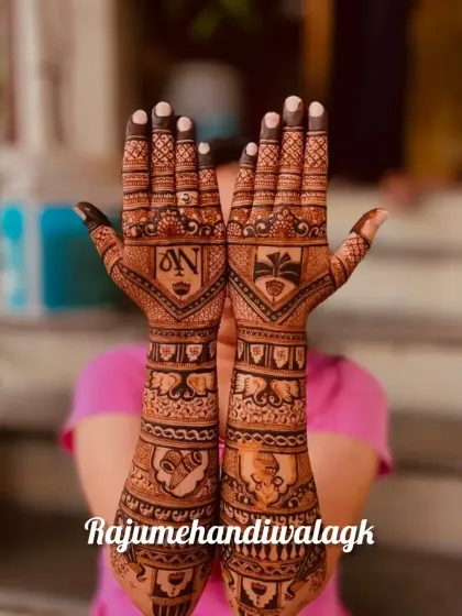 This design features the couple's initials inside a shield-like motif, surrounded by bands of elephants and traditional patterns.