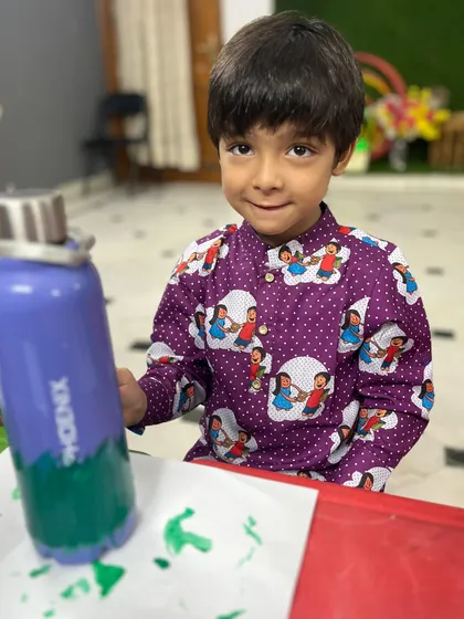 A young artist focused on his creation during our DIY bottle painting workshop. He is carefully painting his insulated water bottle, making a unique and useful piece of art.