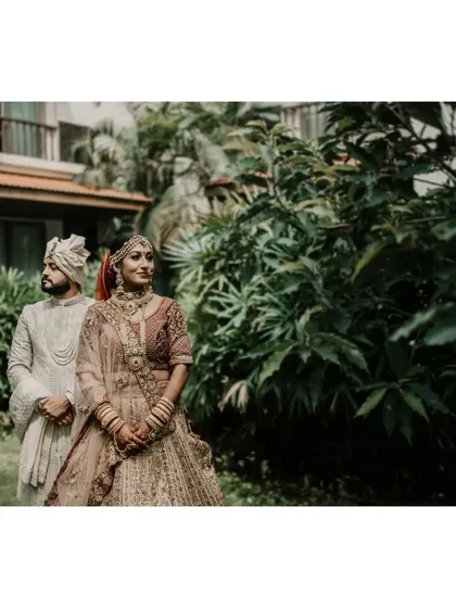 A stunning portrait of Shivangi and Kashyap on their wedding day. Posed against a lush green backdrop, this shot captures the elegance and poise of the couple in their traditional wedding attire.