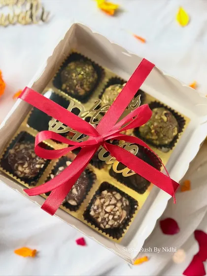 My Diwali 'Sweet Box' tied with a festive ribbon. Inside you'll find Pistachio Mafroukeh, Peanut Butter Stuffed Dates, and Hazelnut Mafroukeh.