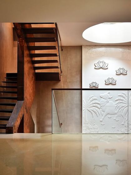 Another perspective of the farmhouse staircase, emphasizing the clean lines of the glass balustrade and the warm texture of the wooden steps. The design creates a sense of weightlessness, turning a functional element into a sculptural focal point.