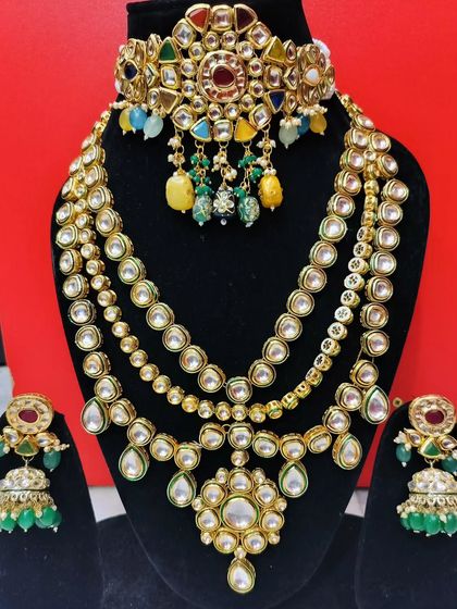 A Navratna choker paired with a multi-layered Polki necklace and green jhumkas.