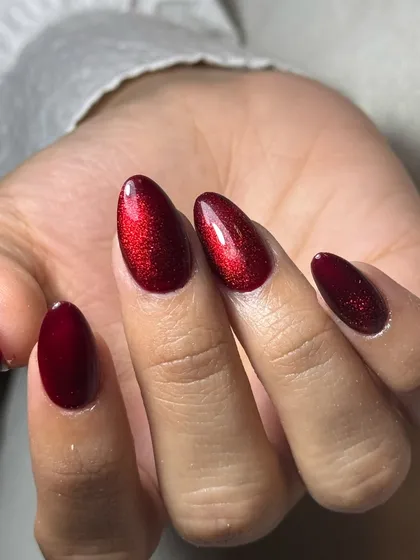 You can never go wrong with a powerful red. This is a stunning red cat-eye effect on perfectly shaped almond nails, giving a deep, magnetic shimmer that changes with the light.