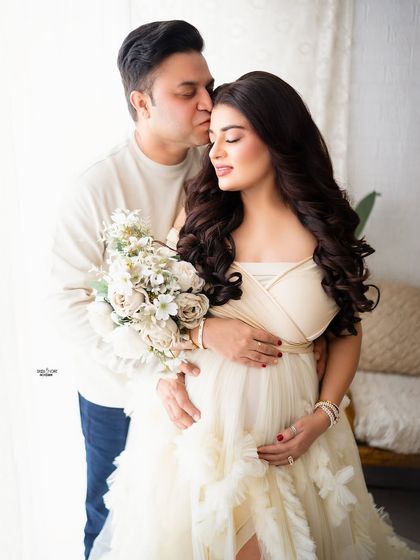 A tender moment between the parents-to-be, with a beautiful bouquet of white flowers. The love in this family is so clear.