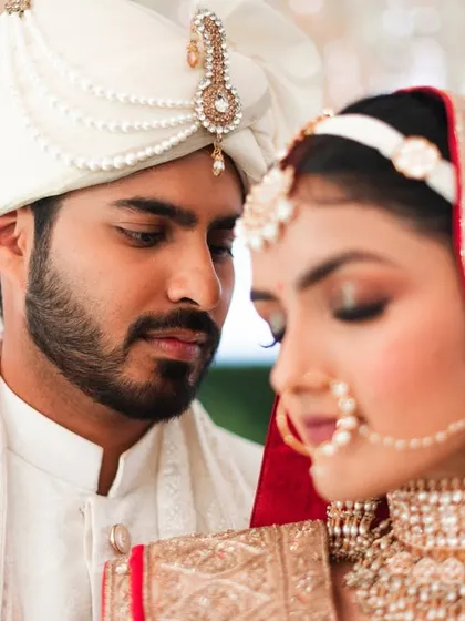 A close-up portrait of the couple on their wedding day. The groom's adoring gaze at his bride is a beautiful, candid moment.