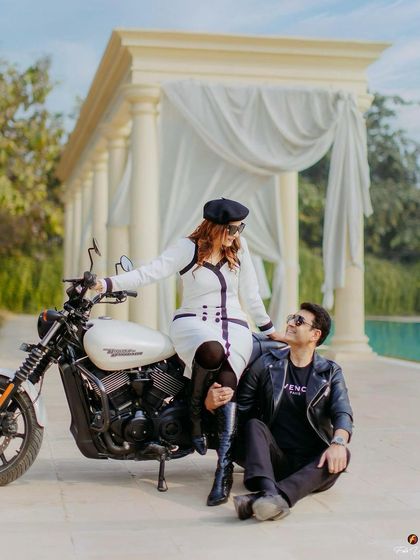 A chic and edgy pre-wedding look featuring a motorcycle. The makeup is bold and confident, with a defined eye and lip that matches her stylish outfit.