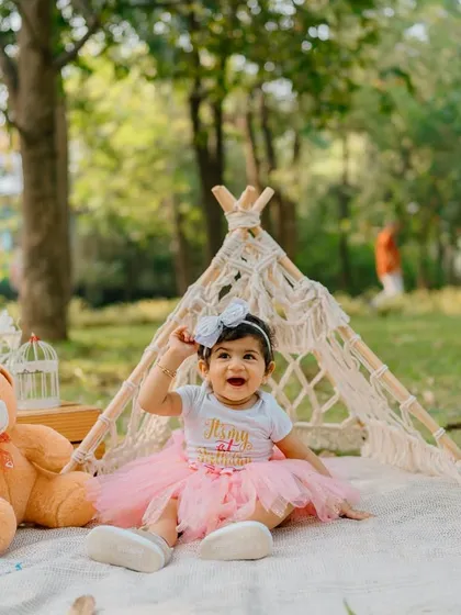 A wider shot of the birthday picnic setup shows the "ONE" blocks and other charming props we can use to personalize your baby's first birthday photoshoot in a park.