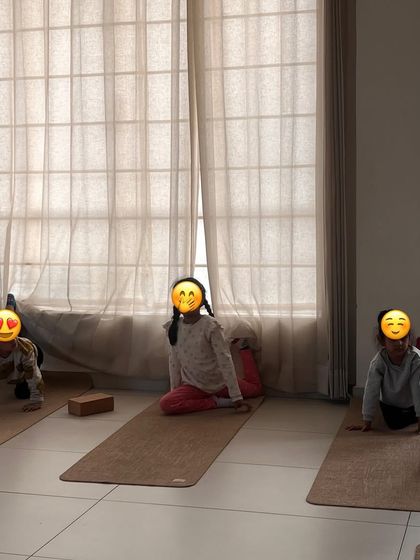 Young students practice a gentle backbend, their faces full of concentration and joy.