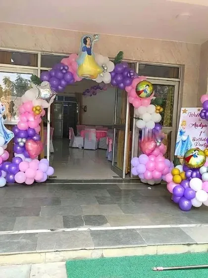 A grand entrance for a princess-themed birthday party, featuring a balloon arch with a Snow White cutout.