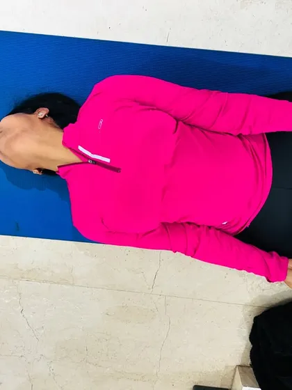 A student practices Matsyasana, or Fish Pose, in a variation with legs in Padmasana (Lotus Pose). This heart opening pose is excellent for improving posture and releasing tension in the neck and shoulders.