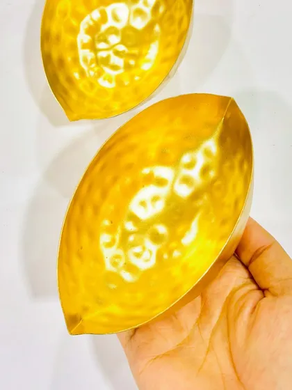 This leaf-shaped hammered metal urli is a simple yet elegant option for holding a single candle or for use as a small decorative dish.