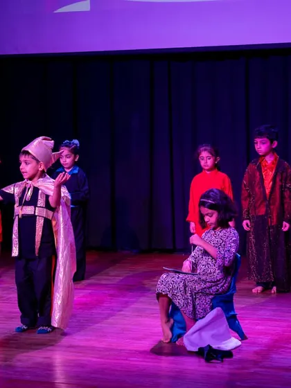The ensemble cast of 'The Emperor's New Clothes' in a key scene. The varied costumes and postures help define each character's role and status.