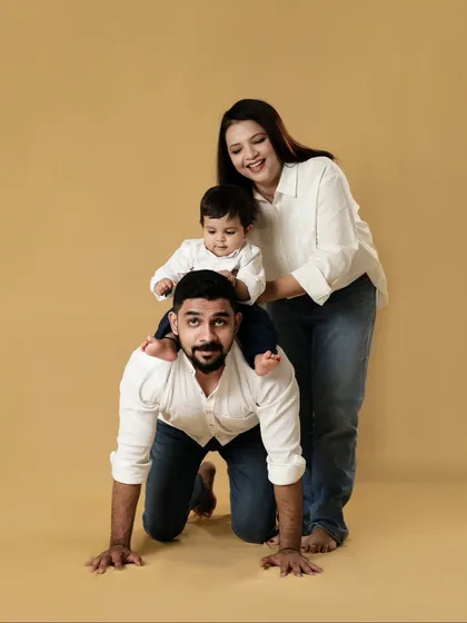 A playful family moment in the studio. The father gives his son a piggyback ride, and the joy on everyone's face is wonderful. We encourage families to play and have fun.