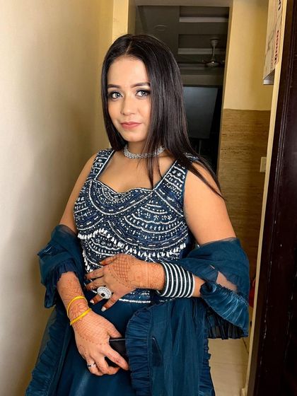 A close-up of the embellished blouse of the dark blue rental lehenga. Paired with a simple diamond necklace, this look is perfect for a bridesmaid.