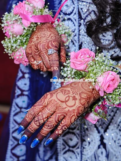 Another angle of the bride's hands with floral jewelry, showing the personalized ring motif.
