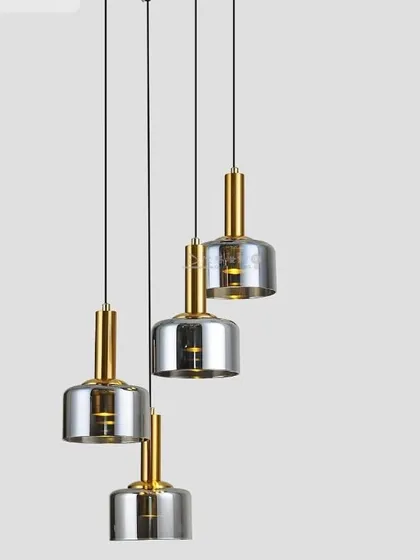 A set of four pendants with smoked glass shades and brass fittings. This is a classic configuration for lighting a kitchen island or dining table.