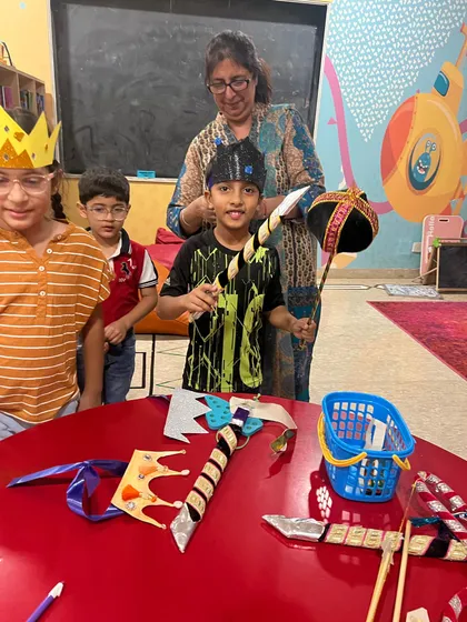 The excitement is building as the children get ready for the Ramleela. They proudly hold their props, eager to get on stage.