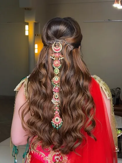 A back view of the royal bridal hairstyle, showcasing a stunning, multi-layered hair accessory cascading down the length of the soft waves.