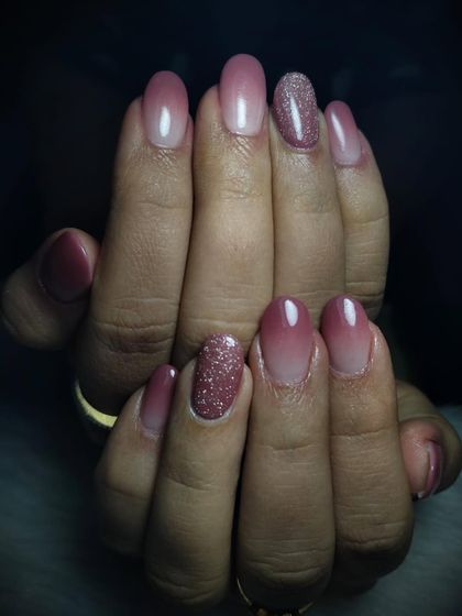 Manicure goals achieved with this beautiful pink ombre design. The color fades from a deep mauve to a soft pink, with a touch of glitter on the accent nail.