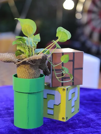 A Super Mario-themed centerpiece featuring a Piranha Plant in a warp pipe and question blocks. This creative detail brings a touch of the virtual world to the party tables.