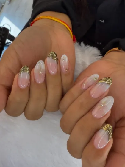 A simple yet elegant design. This set features a sheer base with a soft white ombre, accented with delicate gold wire-like details at the cuticle.