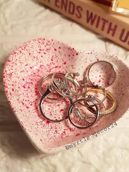 Our mini heart dish with a red speckled finish, filled with an assortment of rings.