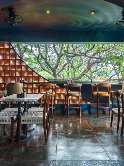 A closer view of the dining area, where the arched ceiling painted with a celestial mural draws the eye. The large window, framed by the arch, connects the imaginative interior with the natural world outside.
