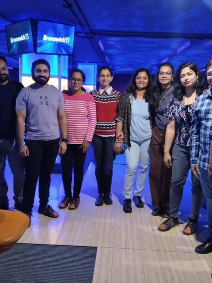 A corporate team poses for a group photo at our bowling alley. Our venue is perfect for hosting company events that are both fun and help with team bonding.