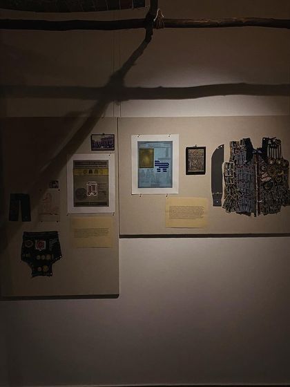 An archival board illuminated by a single light source in the dark gallery.