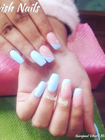 A geometric design with solid light blue nails and accent nails with a color-blocked pink and blue design.