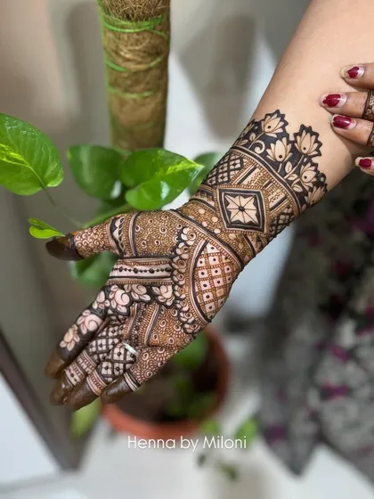 A beautiful example of a non-bridal intricate design, with a mix of geometric and floral patterns covering the hand and wrist.