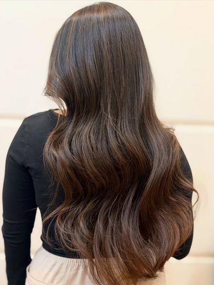 The back view of this caramel brown transformation shows how the color is seamlessly blended for a natural, sun-kissed effect.